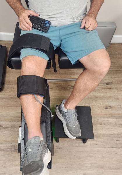 Front view of a patient's knee secured in the Knee-on-Trac® decompression unit at McNamara Chiropractic Center in Lighthouse Point, FL